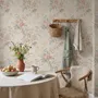 Pink chinoiserie wallpaper with watercolor flowers, blue-grey leaves and red berries on a cream linen-texture ground
