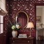 Pink butterflies wallpaper on a claret ground with cream flowers, moons, stars and spotted mushrooms.