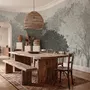 Light gray wallpaper mural with layered ink-wash woodland trees, falling leaves and birds