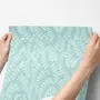 Aqua fern wallpaper with overlapping icy blue palm fronds on a pale aqua ground