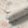 Pink chinoiserie wallpaper with watercolor flowers, blue-grey leaves and red berries on a cream linen-texture ground