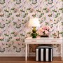 Cute pink wallpaper with birds, tan branches, green leaves and ivory, coral and lilac flowers.