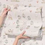Children's playroom wallpaper with pastel Ferris wheel, carousel horses, tents and balloons on blush pink