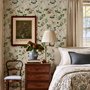 Chinoiserie wallpaper with blue-grey birds, pink peonies, white orchids and green branches on ivory-cream ground