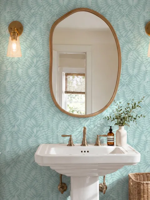 Aqua fern wallpaper with overlapping icy blue palm fronds on a pale aqua ground
