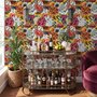 Floral and fish wallpaper with coral blooms, teal fish and black white flowers on metallic mustard-gold ground