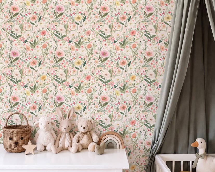 Pink wallpaper with watercolour blush, coral and yellow wildflowers, sage leaves and stems on a warm cream-white ground.