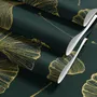Dark green wallpaper with metallic antique-gold etched ginkgo leaves on a textured forest-green teal ground