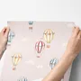 Hot air balloon nursery room wallpaper with watercolour balloons, clouds and stars on a soft blush-pink ground