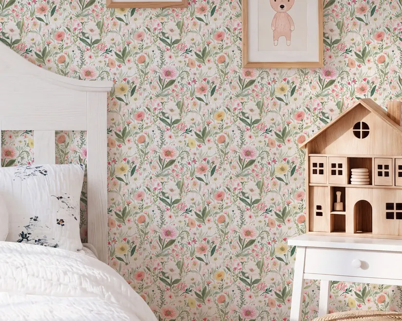Pink wallpaper with watercolour blush, coral and yellow wildflowers, sage leaves and stems on a warm cream-white ground.