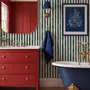 Green striped minimalist wallpaper with vertical deep forest green bands on a soft warm ivory ground.