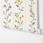 Cute floral wallpaper with green vine trails and pink, purple and yellow watercolor flowers on cream