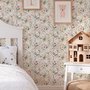 Pink wallpaper with watercolour blush, coral and yellow wildflowers, sage leaves and stems on a warm cream-white ground.