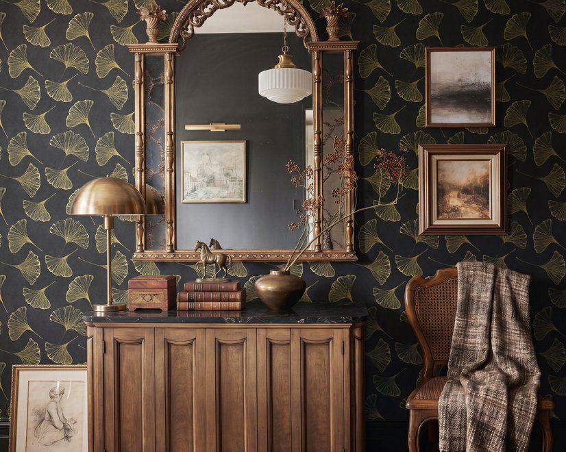 Black wallpaper with antique metallic gold ginkgo leaves on a mottled charcoal ground