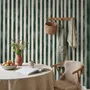 Green striped minimalist wallpaper with vertical deep forest green bands on a soft warm ivory ground.