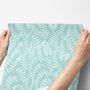 Aqua fern wallpaper with overlapping icy blue palm fronds on a pale aqua ground