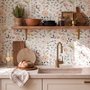 Watercolour wildflower wallpaper with pastel flowers and sage leaves on a white ground