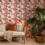 Tropical foliage wallpaper with black panthers, pink palace facades and ochre palms on pale peach