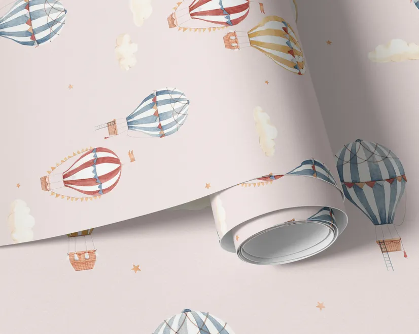 Hot air balloon nursery room wallpaper with watercolour balloons, clouds and stars on a soft blush-pink ground