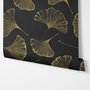 Black wallpaper with antique metallic gold ginkgo leaves on a mottled charcoal ground