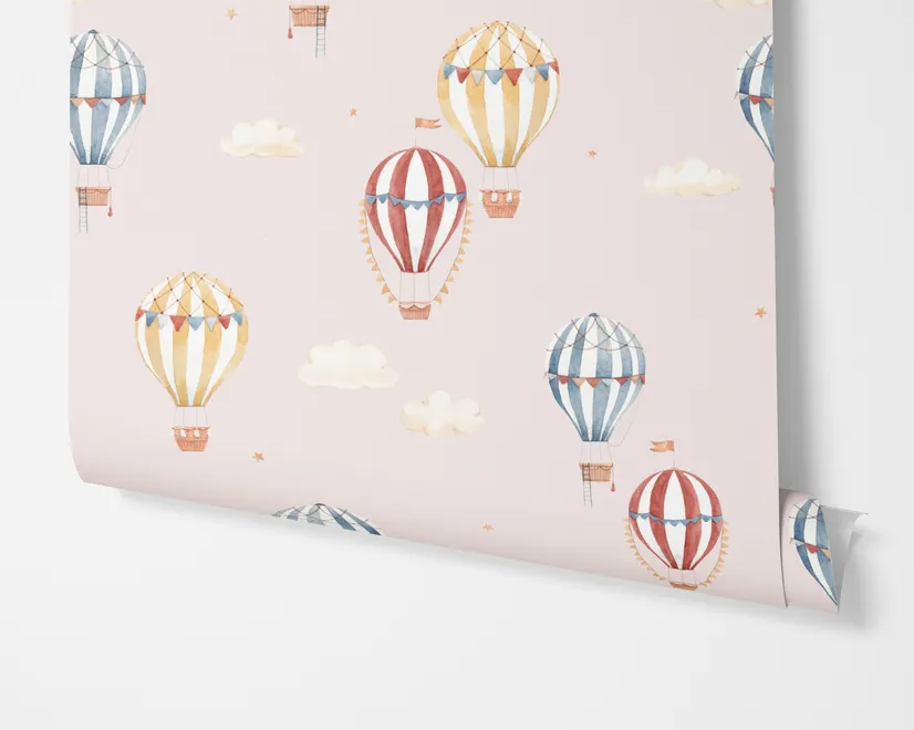 Hot air balloon nursery room wallpaper with watercolour balloons, clouds and stars on a soft blush-pink ground