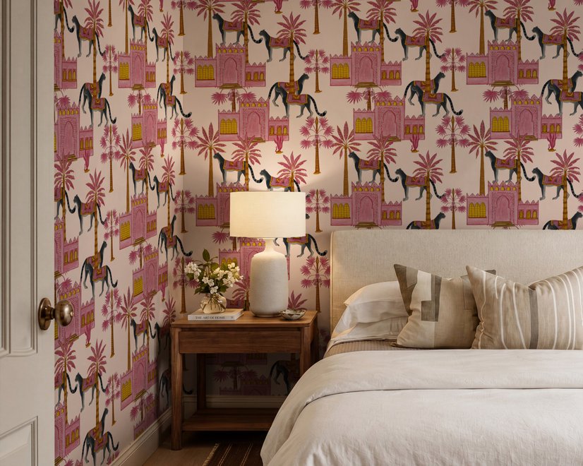 Tropical foliage wallpaper with black panthers, pink palace facades and ochre palms on pale peach