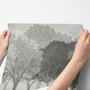 Light gray wallpaper mural with layered ink-wash woodland trees, falling leaves and birds