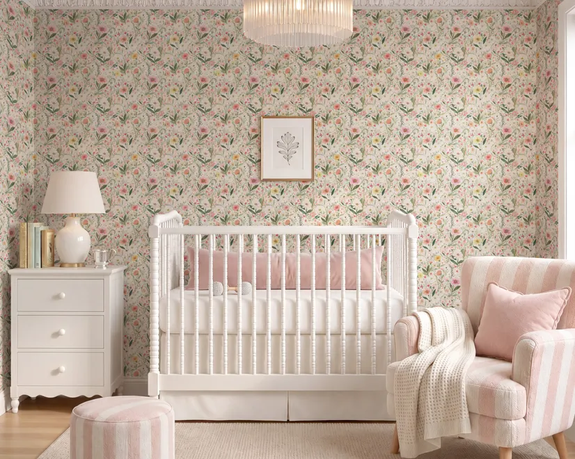 Pink wallpaper with watercolour blush, coral and yellow wildflowers, sage leaves and stems on a warm cream-white ground.