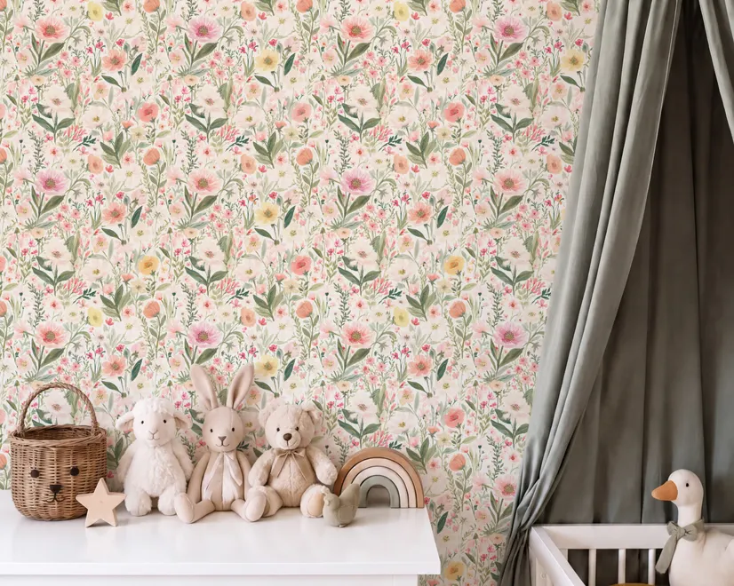 Pink wallpaper with watercolour blush, coral and yellow wildflowers, sage leaves and stems on a warm cream-white ground.