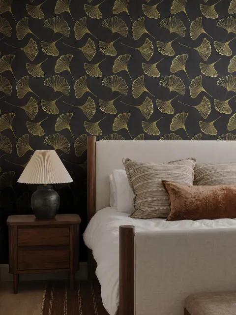 Black wallpaper with antique metallic gold ginkgo leaves on a mottled charcoal ground