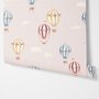 Hot air balloon nursery room wallpaper with watercolour balloons, clouds and stars on a soft blush-pink ground