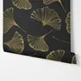 Black wallpaper with antique metallic gold ginkgo leaves on a mottled charcoal ground