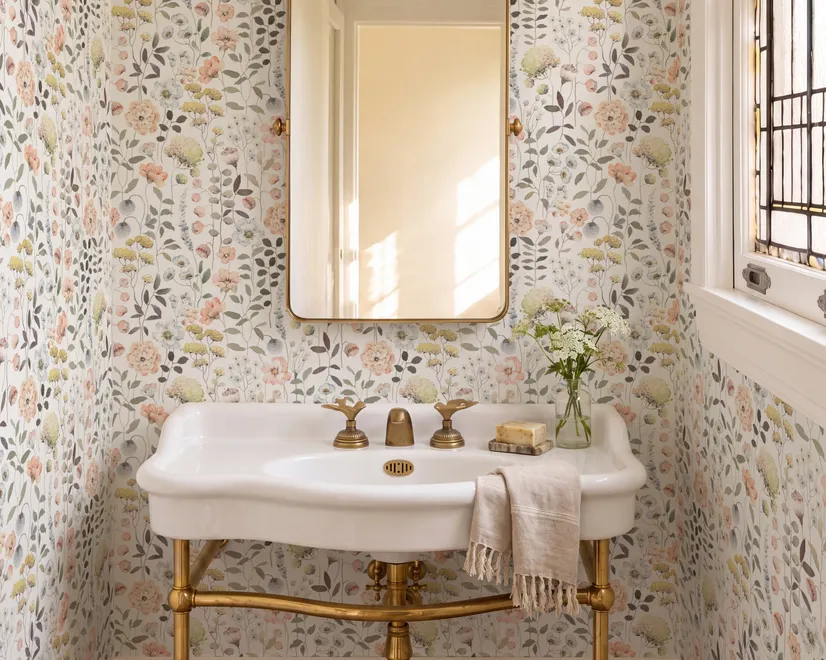 Watercolour wildflower wallpaper with pastel flowers and sage leaves on a white ground