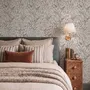 Black outline botanical wallpaper with charcoal wildflowers and grasses on a warm ivory cream ground