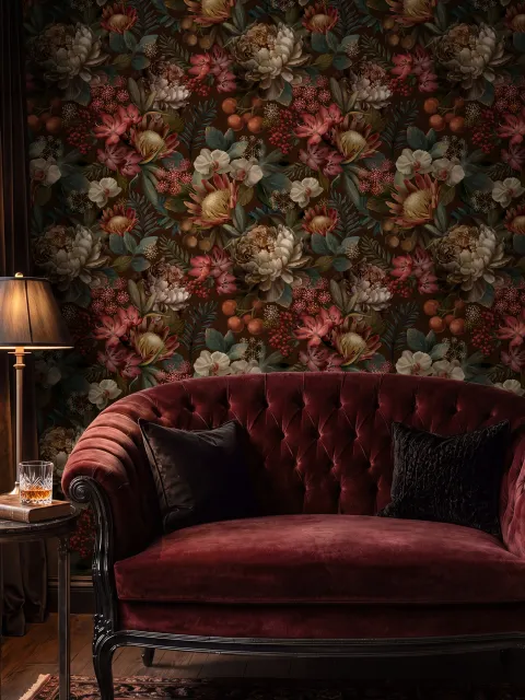 Dark moody floral wallpaper with cream peonies, coral lilies, berries and green foliage on chocolate brown