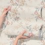 Pink chinoiserie wallpaper with watercolor flowers, blue-grey leaves and red berries on a cream linen-texture ground