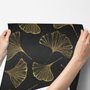 Black wallpaper with antique metallic gold ginkgo leaves on a mottled charcoal ground