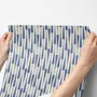 Cream colored wallpaper with denim blue geometric totem stripe repeat on a linen texture ground