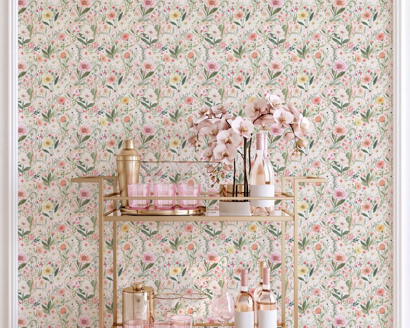 Pink wallpaper with watercolour blush, coral and yellow wildflowers, sage leaves and stems on a warm cream-white ground.