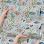 Modern coastal wallpaper with watercolour tropical fish, coral, seaweed, shells and bubbles on light aqua-blue