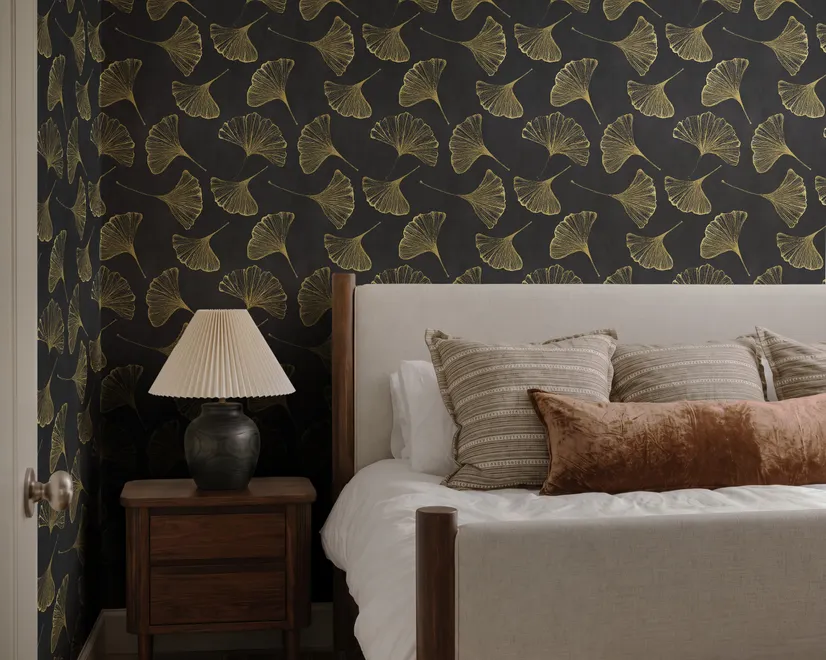 Black wallpaper with antique metallic gold ginkgo leaves on a mottled charcoal ground