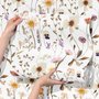 Cute spring wallpaper with pressed ivory, pink, blue and yellow wildflowers on a white ground