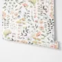 Watercolour wildflower wallpaper with pastel flowers and sage leaves on a white ground