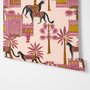 Tropical foliage wallpaper with black panthers, pink palace facades and ochre palms on pale peach